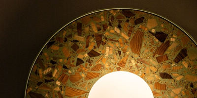 round wall lamp in sage colour made of wood chips